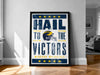 A framed poster with the text "Hail to the Victors" and a graphic of a football helmet, which appears to be a sports-themed poster.