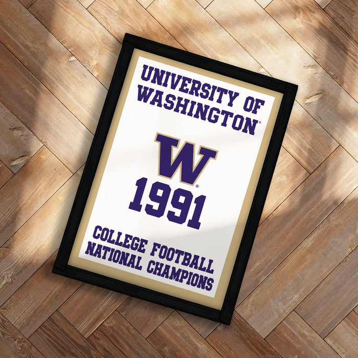A framed poster with the text "UNIVERSITY OF WASHINGTON W 1991 COLLEGE FOOTBALL NATIONAL CHAMPIONS" on it, placed on a wooden floor.