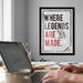 a framed motivational poster with the text "WHERE LEGENDS ARE MADE." in bold, black and red lettering, along with an illustration of an elephant. The poster is displayed on a wall above a desk with a laptop, a coffee mug, and some papers.