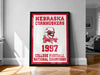 A framed poster celebrating the 1997 Nebraska Cornhuskers College Football National Champions, featuring the team's logo and the text "Nebraska Cornhuskers 1997 College Football National Champions".