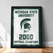 A framed poster celebrating the Michigan State University's 32-7 National Champions, with the university's logo and the year 2000 prominently displayed.