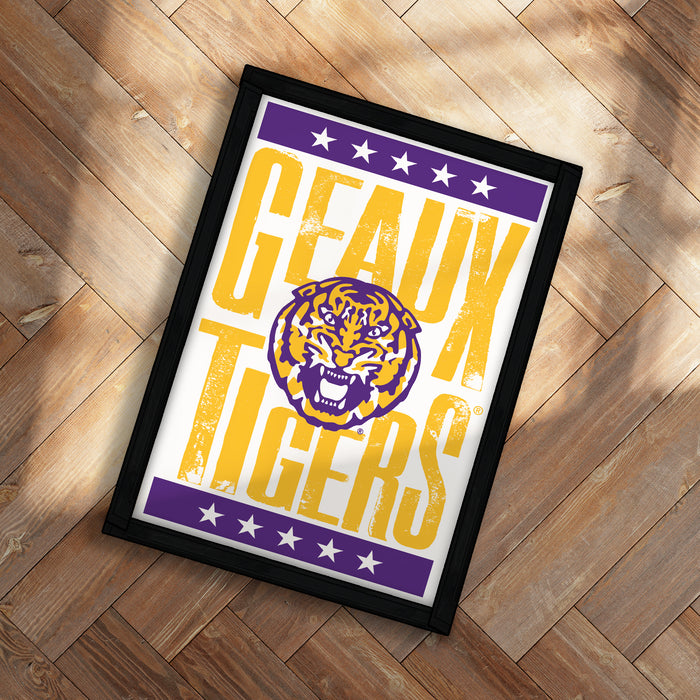 A framed poster with the text "GEAUX TIGERS" and a graphic of a tiger's head, placed on a wooden floor.
