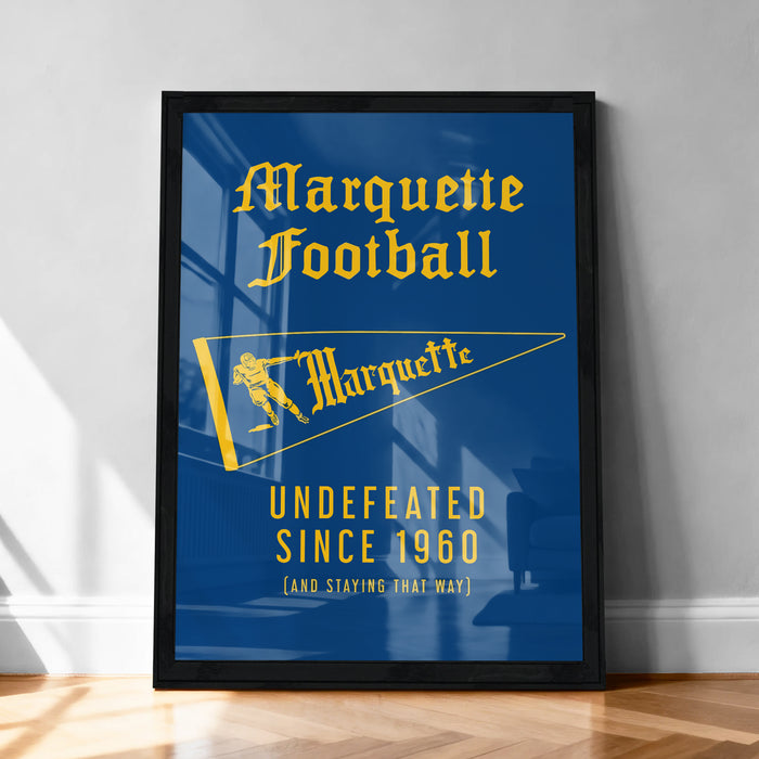 A framed poster with the text "Marquette Football" and "UNDEFEATED SINCE 1960" displayed on a blue background.