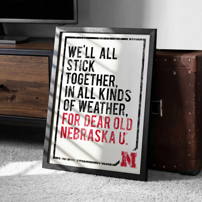 a framed poster with a motivational quote in bold red and black text, placed on a carpeted floor next to a wooden chest.