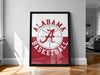 A framed poster of the Alabama basketball team logo is displayed on a wall in a room.