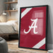 A framed poster with the letter "A" on it is displayed on a wall in a bedroom.