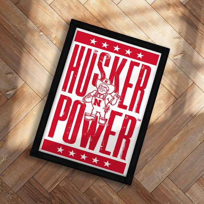 A framed poster with the text "KUSKER POWER" and an illustration of a cowboy character.