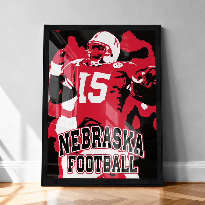 A framed poster featuring a football player in a red and white uniform with the number 15, along with the text "NEBRASKA FOOTBALL".