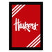 A framed poster with a red background and white diagonal stripes. The poster prominently displays the word "Huskies" in a stylized white font.