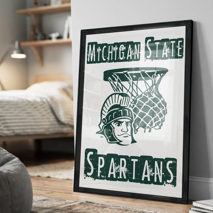 A framed poster featuring the Michigan State Spartans logo and a basketball net, with the text "Michigan State SPARTANS" prominently displayed.