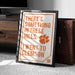 a framed poster with the text "THERE'S SOMETHING IN THESE HILLS. I WENT TO CLAMS" and an orange paw print symbol.