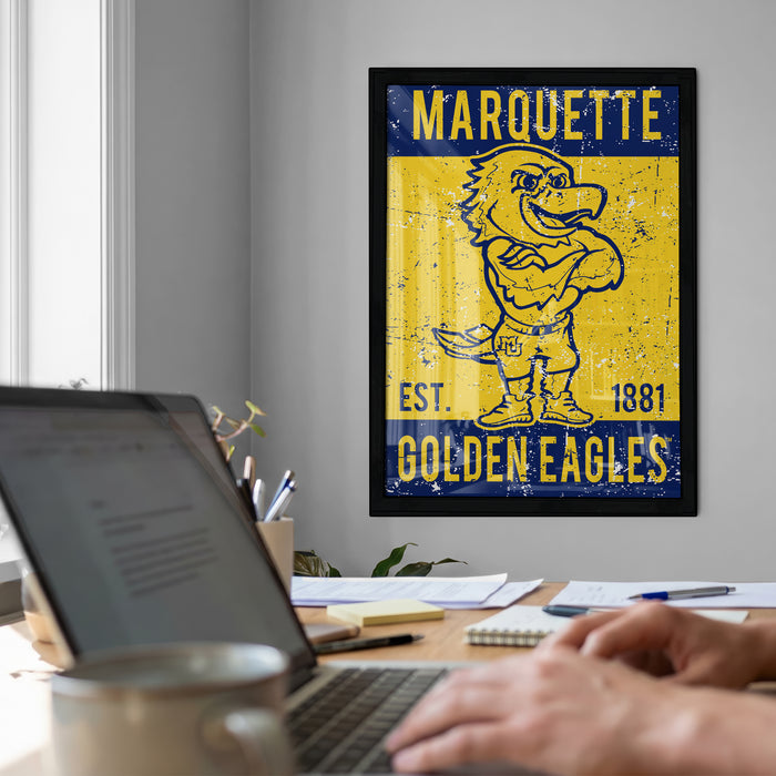 a framed poster of a cartoon eagle on a wall, with a laptop and a coffee cup on a desk in the foreground.
