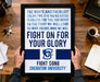 A framed poster with a motivational message is being held by a person's hands, placed on a wooden desk.