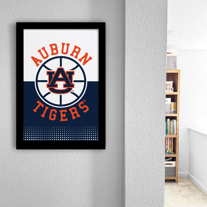 a framed poster of the Auburn Tigers basketball team logo, which is displayed on a wall in a room.