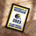 A framed poster with the text "UNIVERSITY OF MICHIGAN" and "2023" on it, along with a football helmet and the text "COLLEGE FOOTBALL NATIONAL CHAMPIONS".