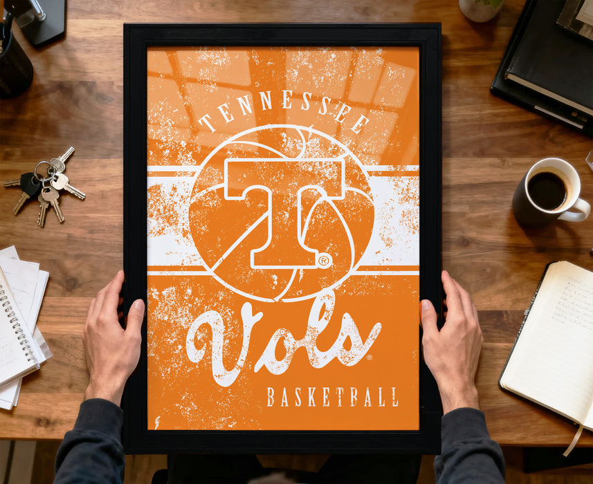 A person is holding up a framed poster with the text "TENNESSEE Vols" and "BASKETBALL" on it, which appears to be a sports-themed artwork.