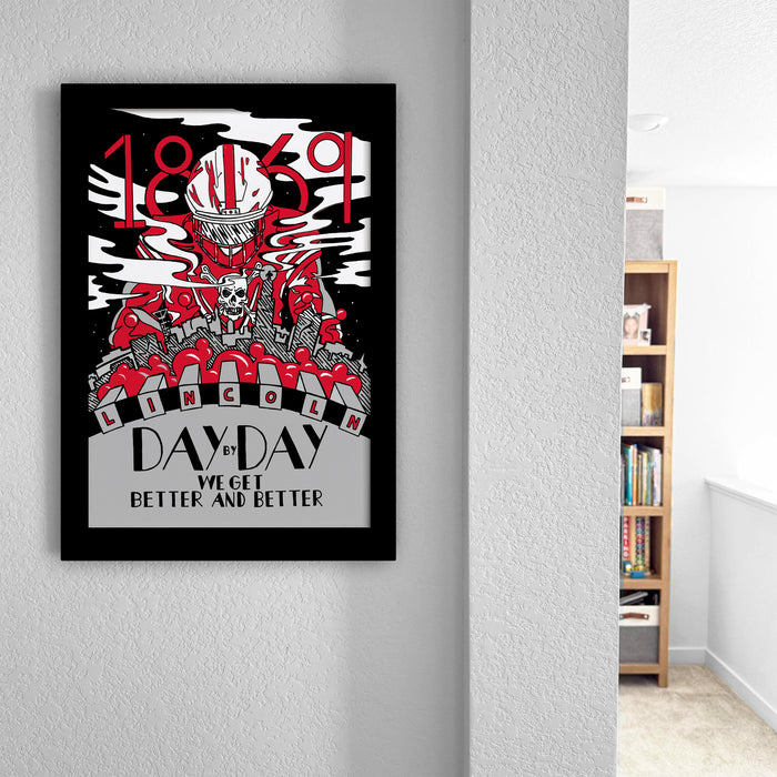 a framed poster with a black and red design, hanging on a wall.