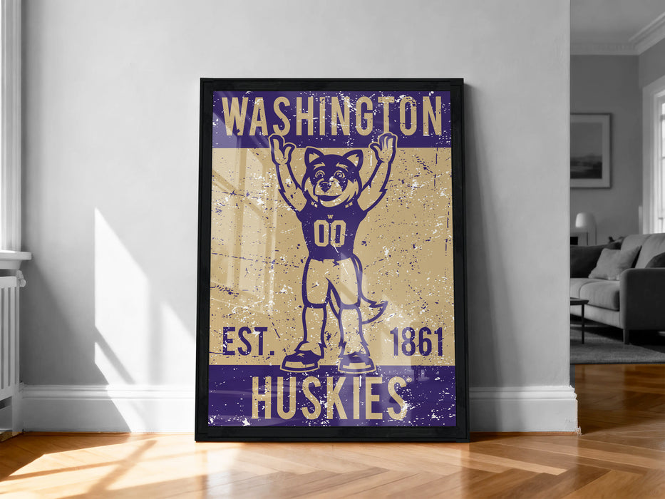 A framed poster featuring a cartoon character wearing a football uniform with the text "WASHINGTON EST. 1861 HUSKIES" on it.