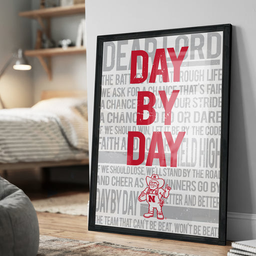 a poster with the text "DAY BY DAY" prominently displayed in large red letters.