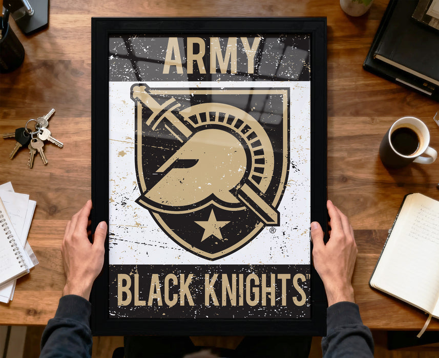 A framed poster with the text "ARMY BLACK KNIGHTS" and a graphic of a helmet and sword, held by a person's hands.