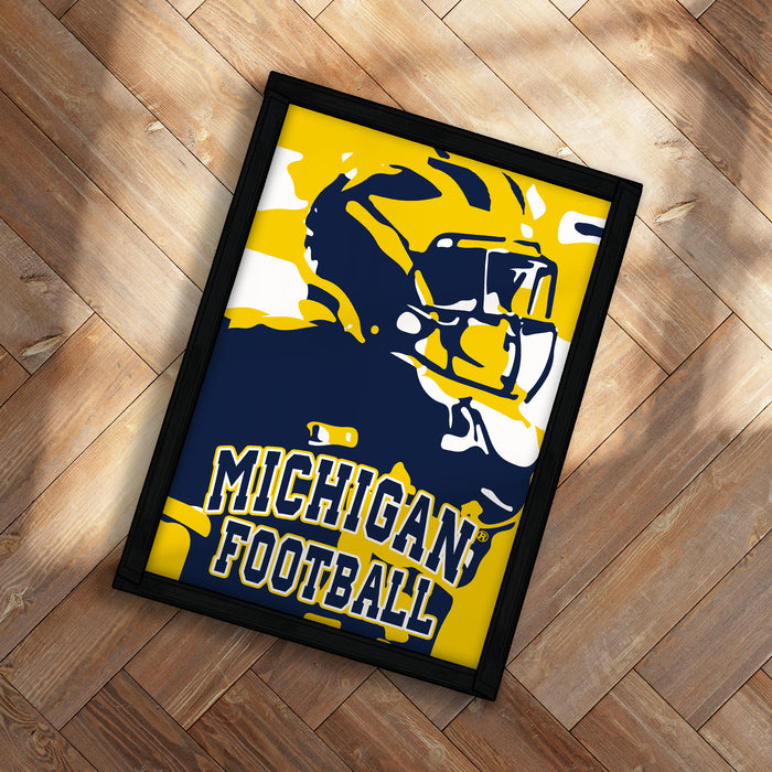 A framed poster featuring a football player in a yellow and blue uniform, with the text "MICHIGAN FOOTBALL" displayed prominently.
