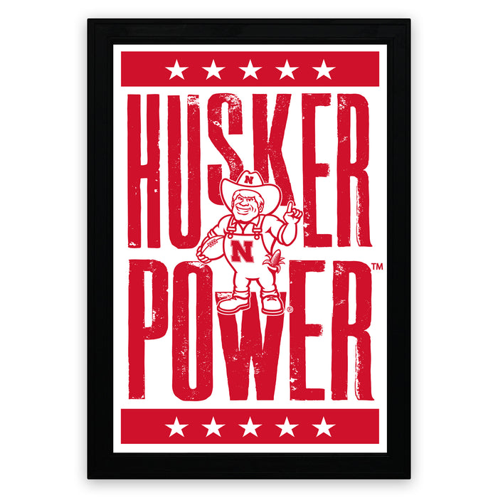 A framed poster with the text "HUSKER POWER" and a cartoon character, likely representing a sports team or brand.