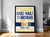 a framed poster with text that reads "Hail! To the victors! Valiant! Hail! To the conouring heroes! Hail! To Michigan! The champions of the west! Fight Song University of Michigan!"