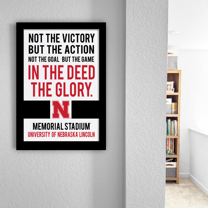a framed quote on a wall that reads "NOT THE VICTORY BUT THE ACTION NOT THE GOAL BUT THE GAME IN THE DEED THE GLORY. MEMORIAL STADIUM UNIVERSITY OF NEBRASKA LINCOLN".