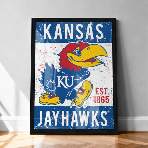 A framed poster featuring the Kansas Jayhawks, a Kansas University sports team, with a large bird mascot and the team's name prominently displayed.