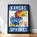 A framed poster featuring the Kansas Jayhawks, a Kansas University sports team, with a large bird mascot and the team's name prominently displayed.