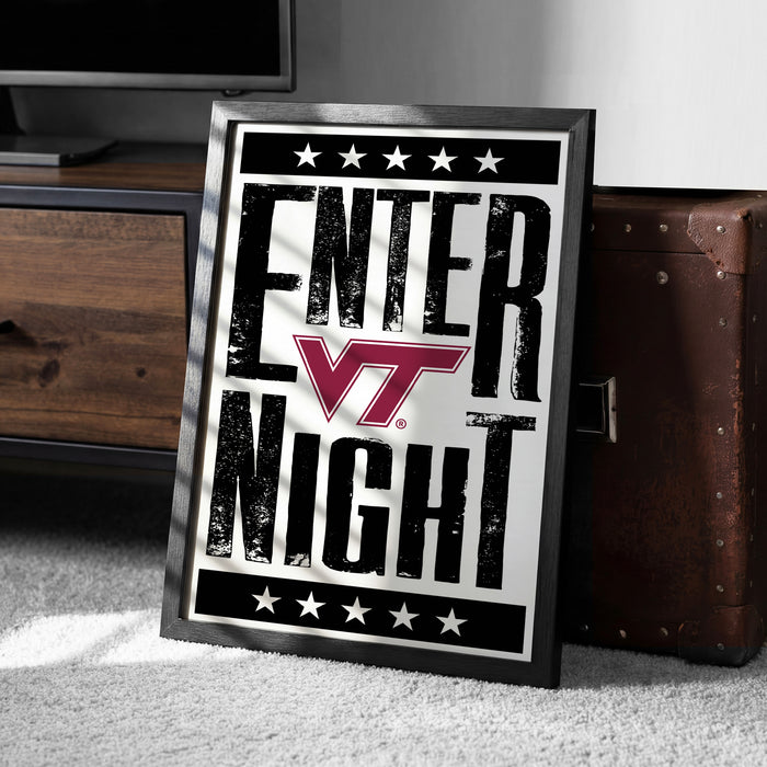 A framed poster with the text "ENTER NIGHT" and a Virginia Tech logo, placed on a carpeted floor next to a wooden chest.