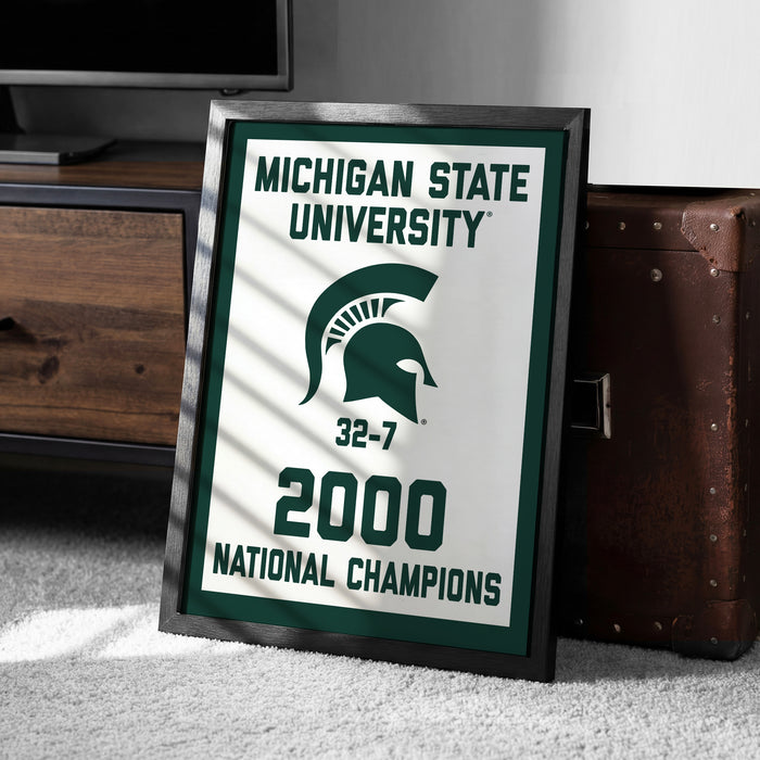 A framed poster celebrating the Michigan State University (MSU) National Champions, with the text "Michigan State University" and "2000 National Champions" prominently displayed.