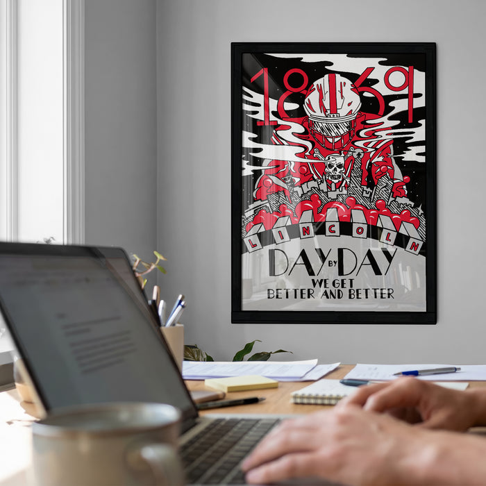 A framed poster with a black and white illustration of a skull and crossbones, along with the text "1859" and "NICOLM" is displayed on the wall above a desk with a laptop and other office supplies.