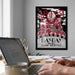 A framed poster with a black and white illustration of a skull and crossbones, along with the text "1859" and "NICOLM" is displayed on the wall above a desk with a laptop and other office supplies.