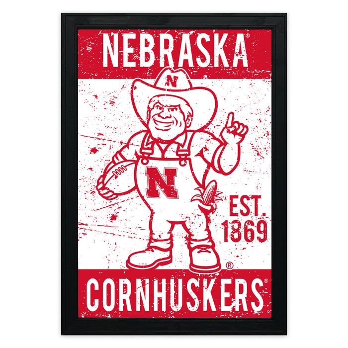 a red and white poster with the text "NEBRASKA CORNHUSKERS" and "EST. 1869". The poster also includes a cartoon character wearing a cowboy hat and holding a football.
