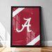 A framed poster with a large white "A" on a red background, placed on a wooden floor against a white wall.