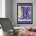 a framed poster of the University of Washington's "Go DAWG'S" team on the wall, with a laptop and desk in the foreground.