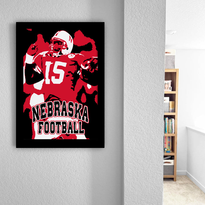 a framed poster of a football player wearing a Nebraska football jersey, with the text "NEBRASKA FOOTBALL" prominently displayed.