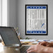 A framed poster with the text "FIGHTIN' FALCONS" hangs on a wall above a desk with a laptop and other office supplies.