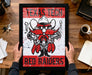 A framed poster featuring a cartoon character with a gun and the text "Texas Tech Red Raiders" is being held by a person's hands.