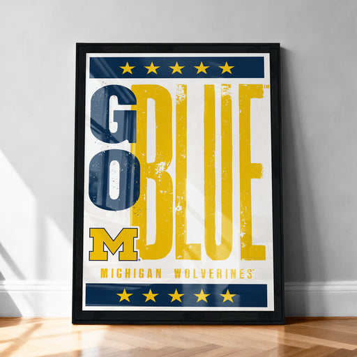 A framed poster with the text "GO BLUE" prominently displayed, along with the logo of the Michigan Wolverines.