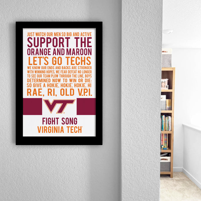 The image is a framed poster with text that reads "Just watch our men so big and active support the orange and maroon let's go techs. We know our teams and basics are strong with winning hopes, we fear defeat no longer to see you through the line boys. Determined now to win the techs. So give a hokey, hokey. hi Rae, R1, OLD VP1." The poster is hanging on a wall, and there is a bookshelf visible in the background.