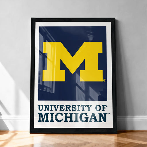 A framed poster of the University of Michigan logo, featuring the university's name and logo prominently displayed.