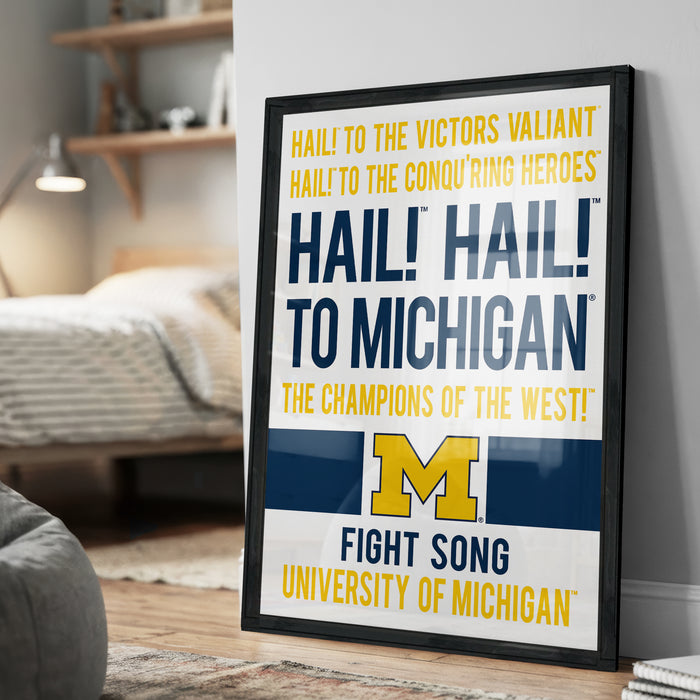 a framed poster with text that reads "Hail! To Michigan! The champions of the West! Fight Song University of Michigan".