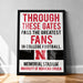 A framed poster with text that reads "THROUGH THESE GATES PASS THE GREATEST FANS IN COLLEGE FOOTBALL. MEMORIAL STADIUM UNIVERSITY OF NEBRASKA LINCOLN"