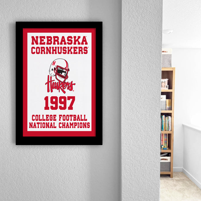 A framed poster on a wall displaying the Nebraska Cornhuskers' 1997 College Football National Champions.
