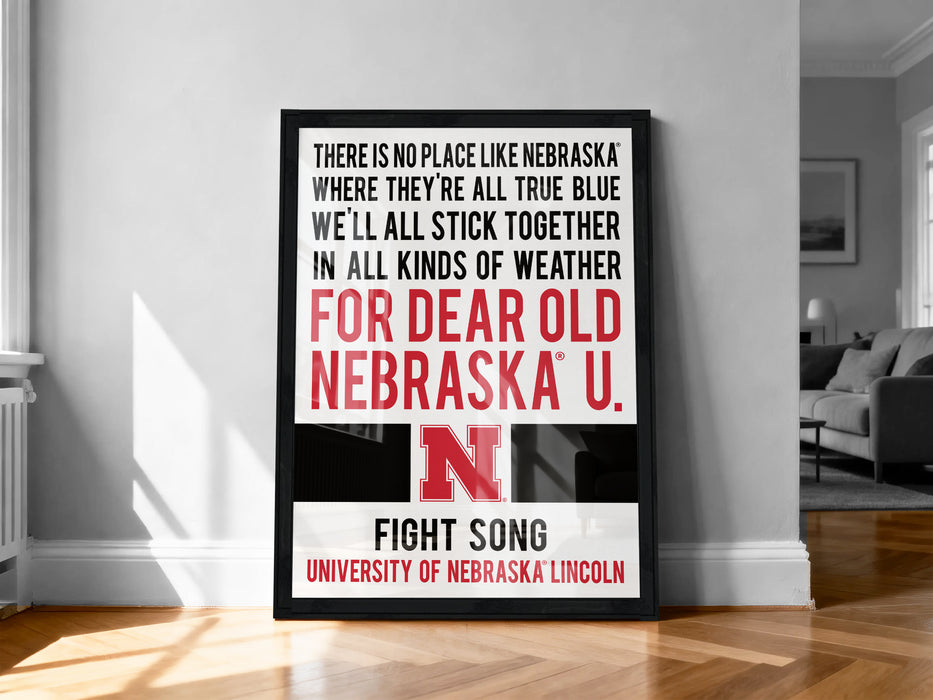 a framed poster with text that reads "There is no place like Nebraska where they're all true blue, we'll all stick together in all kinds of weather for dear old Nebraska U. FIGHT SONG UNIVERSITY OF NEBRASKA LINCOLN".