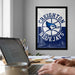 A framed poster of the Toronto Blue Jays basketball team hangs on a wall, with a laptop and coffee mug on a desk in the foreground.