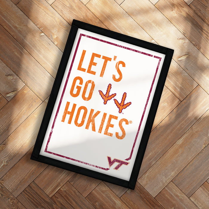 A framed poster with the text "LET'S GO HOKIES" and two orange bird silhouettes is displayed on a wooden floor.