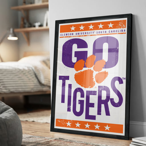 A framed poster with the text "GO TIGERS" and an orange and purple tiger paw design, along with the text "CLEMSON UNIVERSITY SOUTH CAROLINA" and "THE GO TIGERS" printed on it.